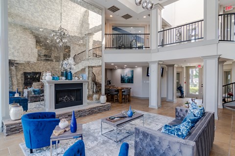 a large living room with a fireplace and blue furniture